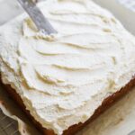 Offset spatula spreading vanilla bean mascarpone frosting on a cake.
