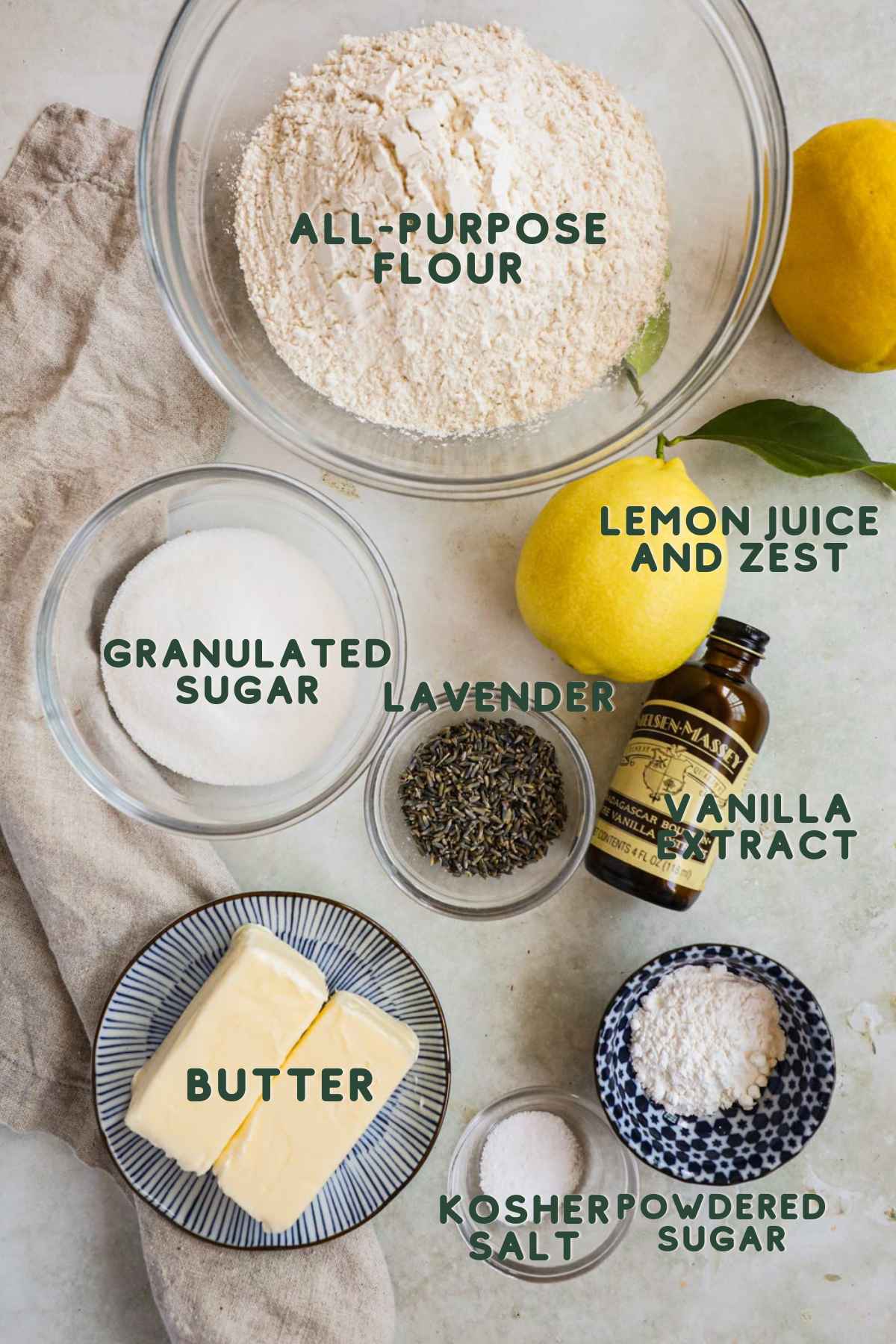 Ingredients for lemon lavender shortbread cookies, flour, lemon juice and zest, sugar, lavender, vanilla extract, salt, butter, powdered sugar.