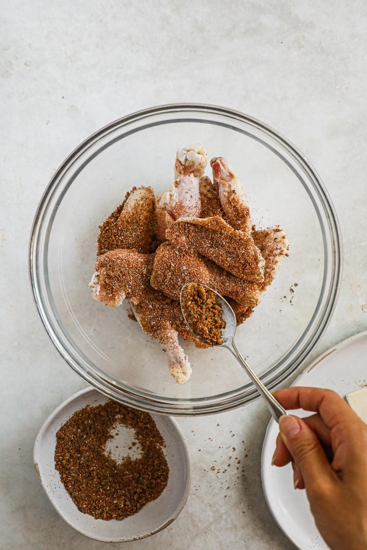 Brown sugar seasoning for chicken wings, ribs, and more in a bowl with chicken wings.