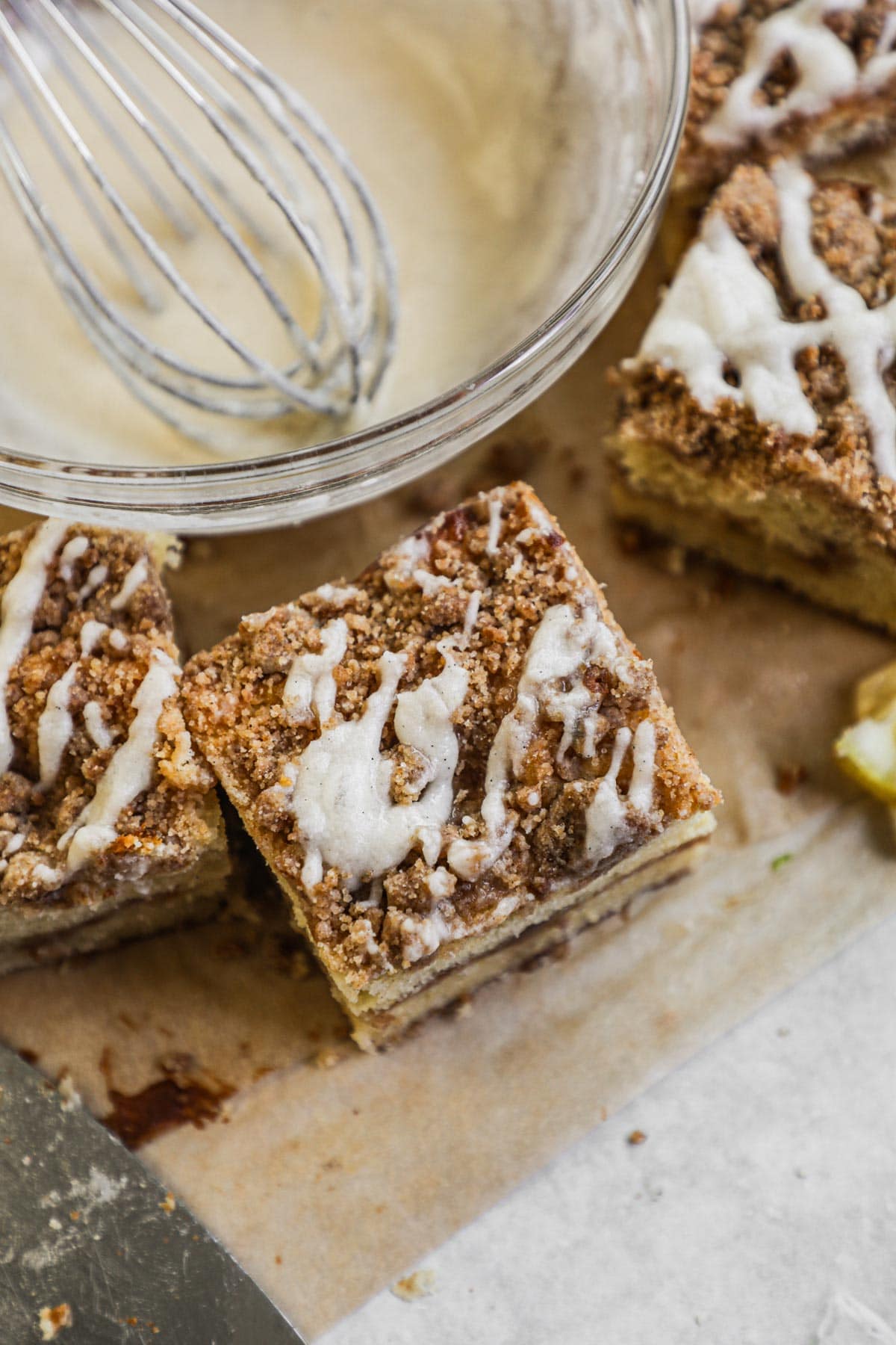 Easy classic vanilla bean icing drizzled on a slice of coffee cake.