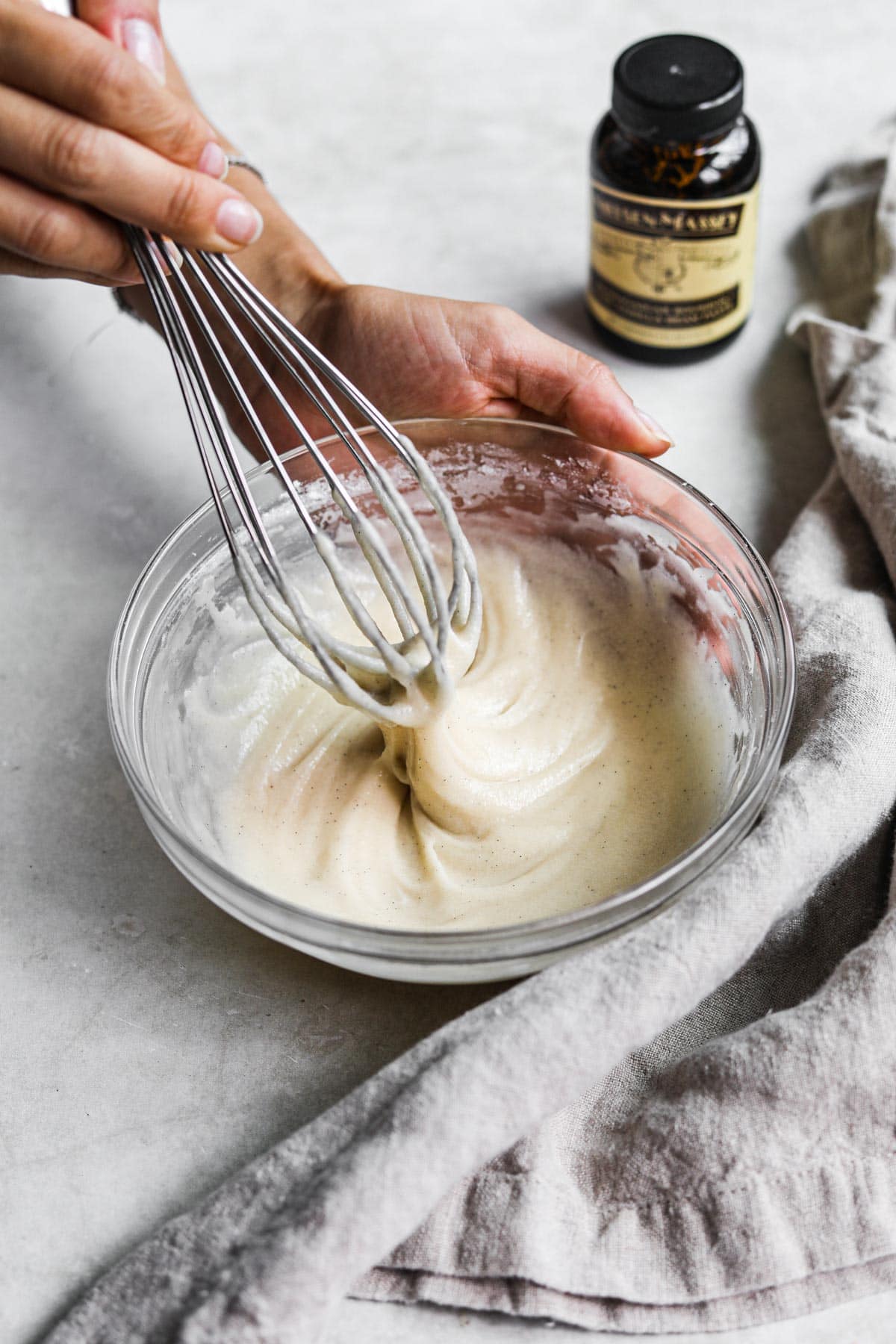 Hand whisking easy vanilla bean icing for muffins, cakes, cinnamon rolls, scones, and more.