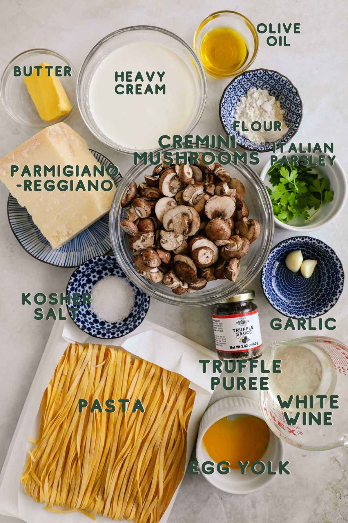 Ingredients to make black truffle mushroom pasta, mushrooms, heavy cream, butter, flour, italian parsley, parmigiano-reggiano, garlic, truffle puree, white wine, egg yolk, pasta, salt.