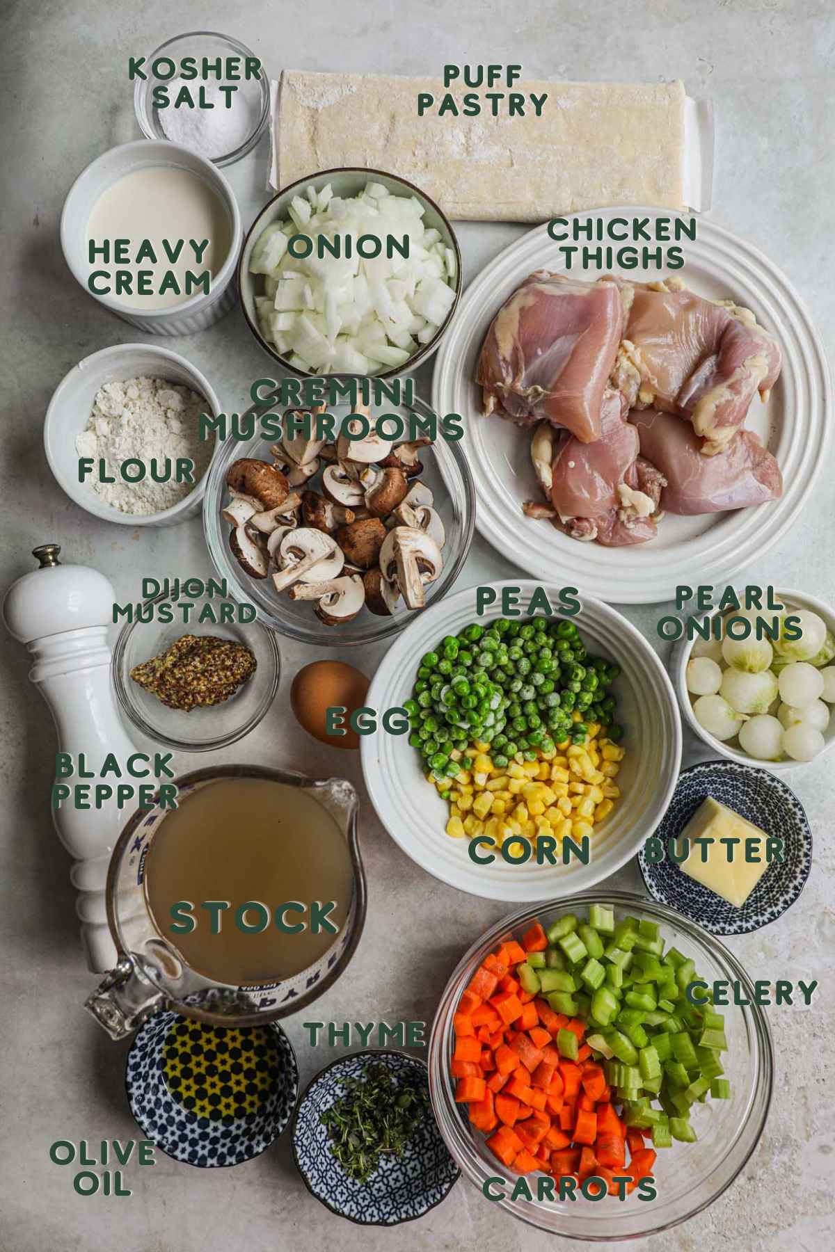 Ingredients to make puff pastry chicken pot pie, puff pastry, heavy cream, onion, chicken, mushrooms, flour, mustard, peas, carrots, butter, thyme, celery, carrots, stock.