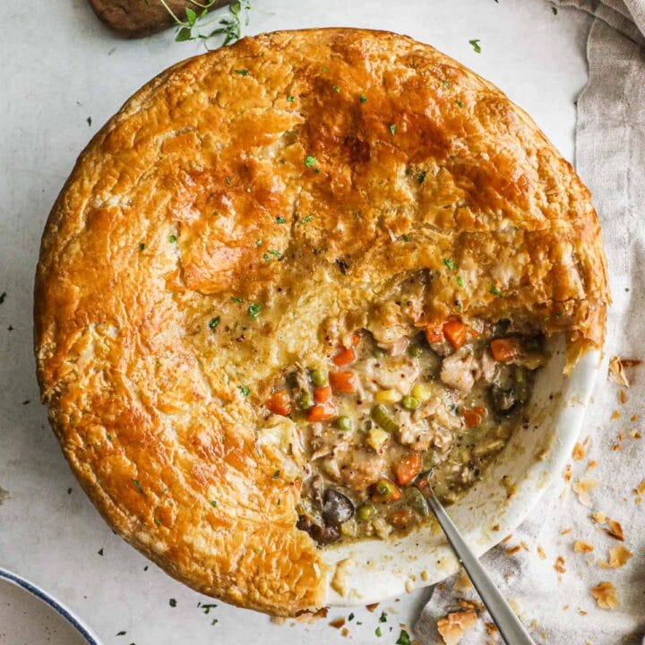 Puff pastry chicken pot pie filled with chicken thighs, carrots, peas, onions, mushrooms, and celery with a golden crust.