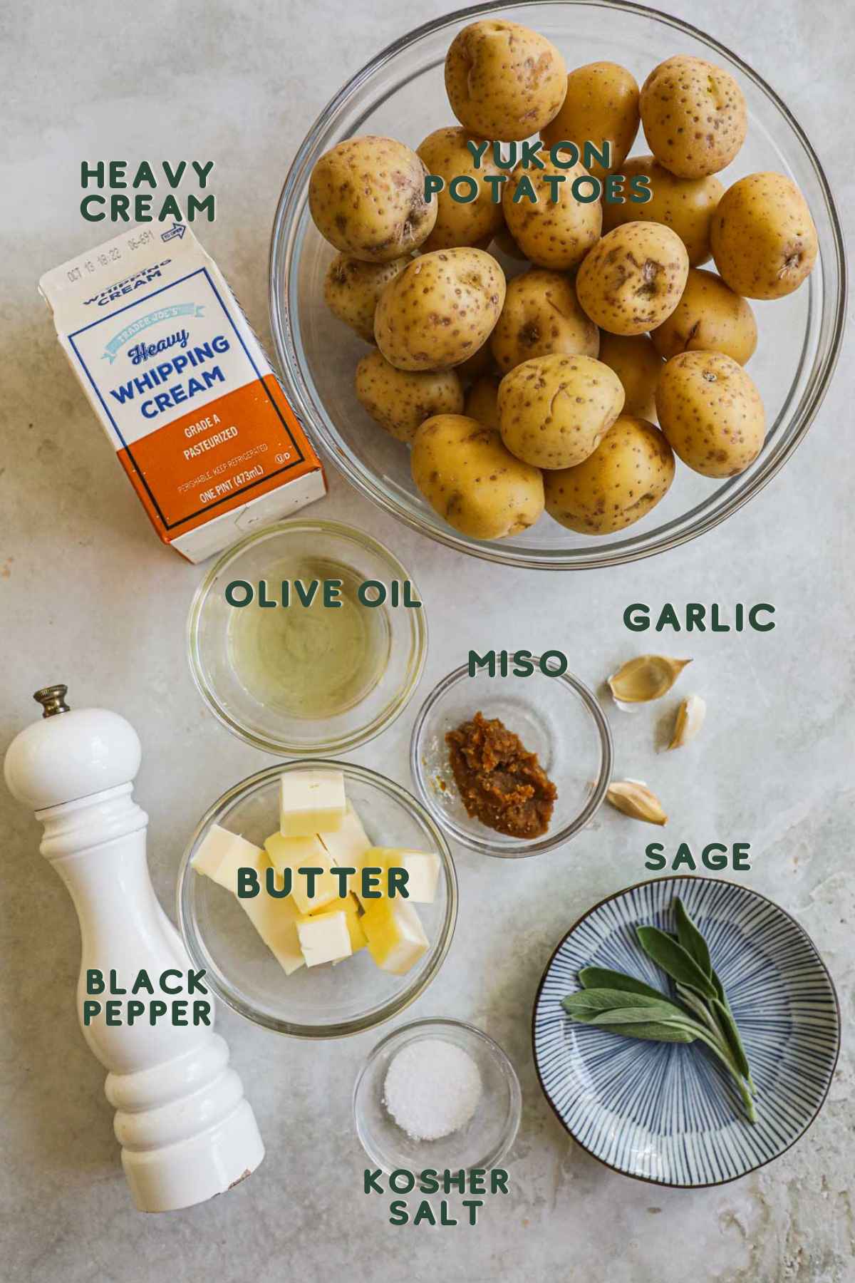 Ingredients to make miso mashed potatoes, yukon potatoes, heavy cream, olive oil, garlic, miso, sage, butter, black pepper, kosher salt.