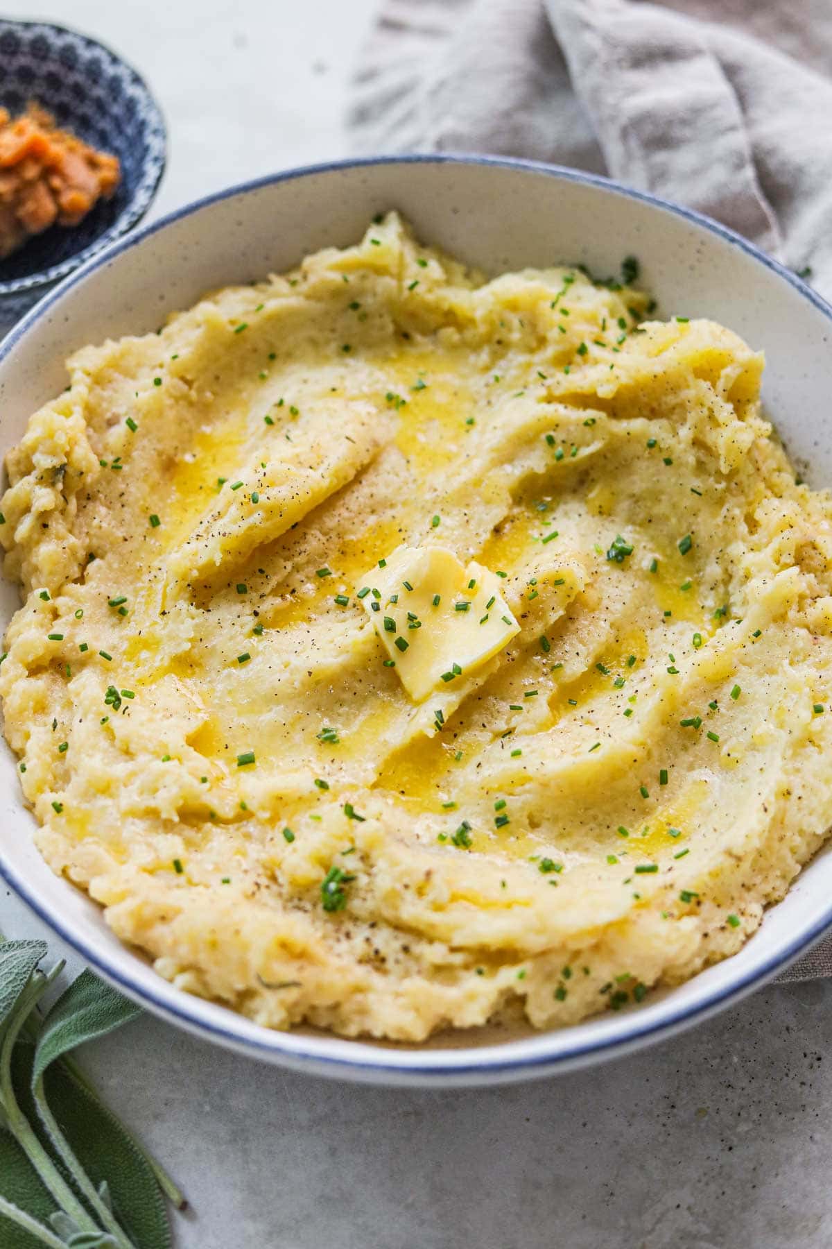Closeup shot of miso mashed potatoes with sage, chives, and butter in a bowl.