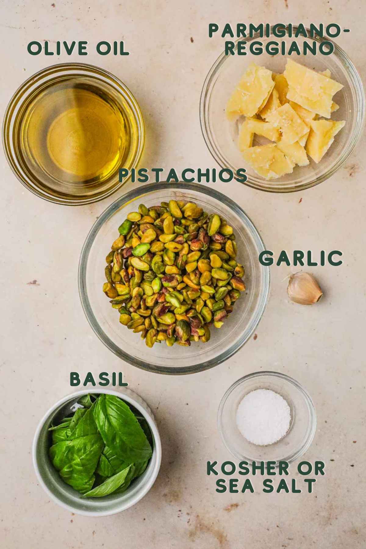 Ingredients for pistachio pesto, pistachios, parmigiano-reggiano, basil, garlic, olive oil, kosher or sea salt.