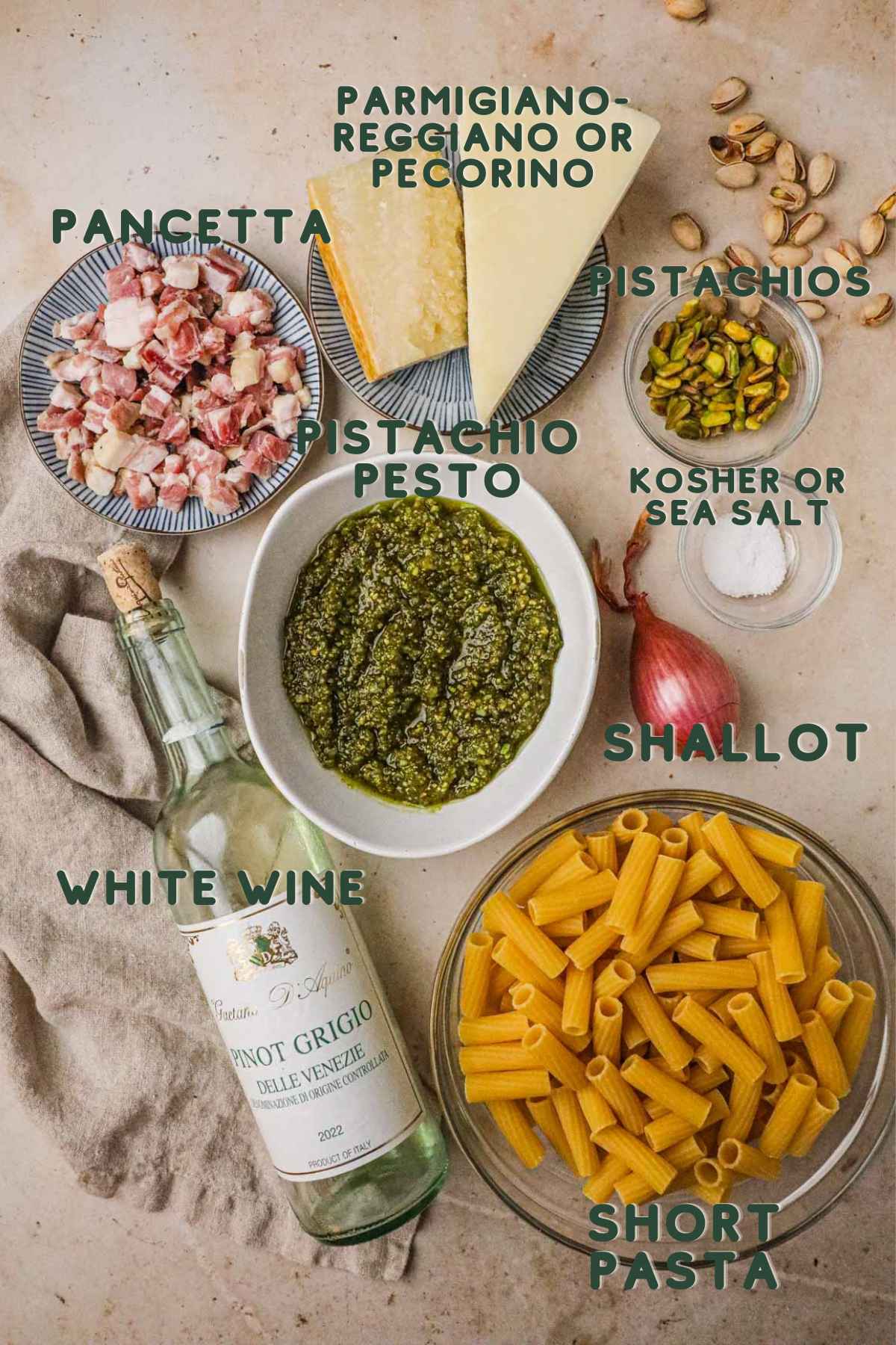 Ingredients to make pistachio pesto pasta, pancetta, pistachio pesto, parmigiano-reggiano, white wine, shallot, kosher salt, pistachios, rigatoni.