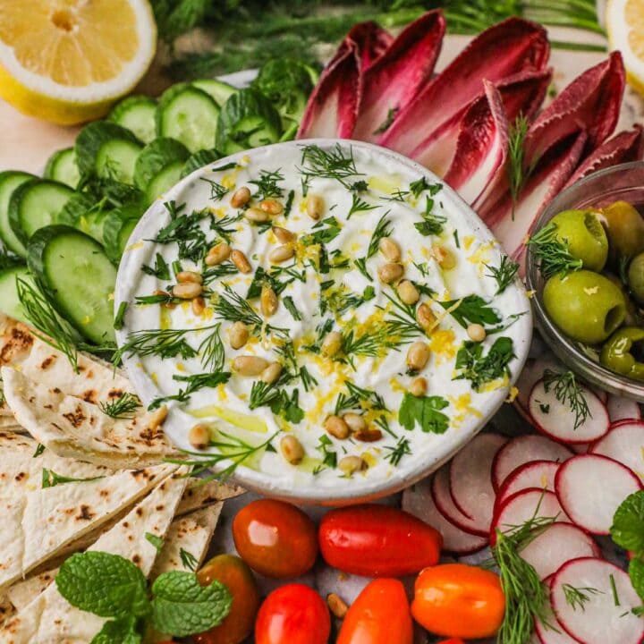 Whipped lemon feta dip topped with toasted pine nuts, herbs, and olive oil and served with toasted pita, crudités, and olives.