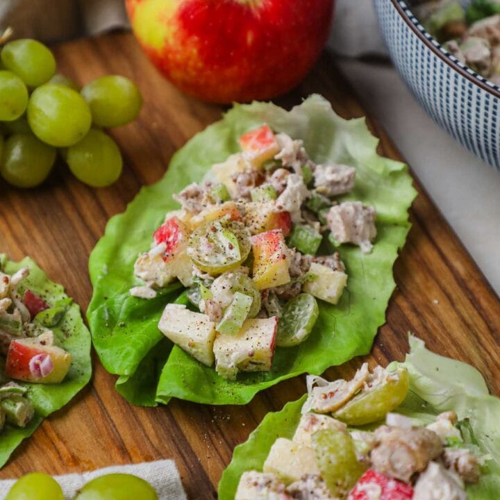 Healthy chicken salad lettuce wrap cups served on a wooden board for a delicious, satisfying lunch.