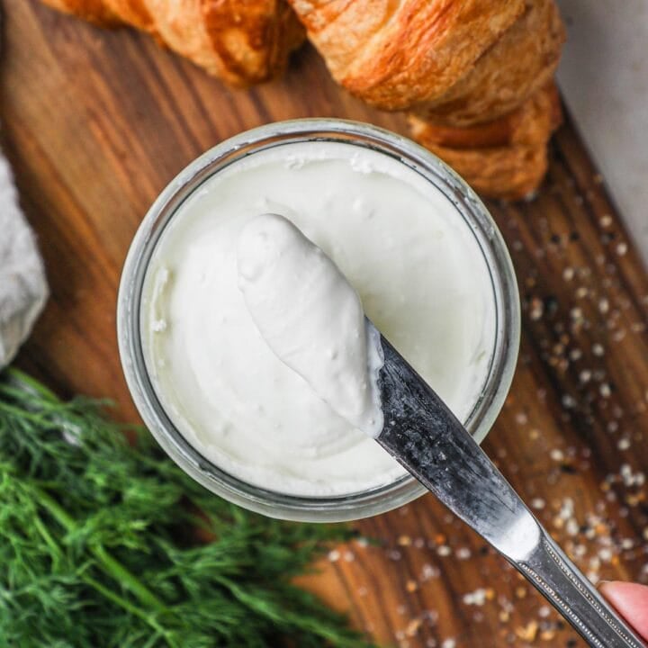 Knife with a scoop of homemade 2-ingredient cream cheese, used for cheesecake, bagel, toast, and more.