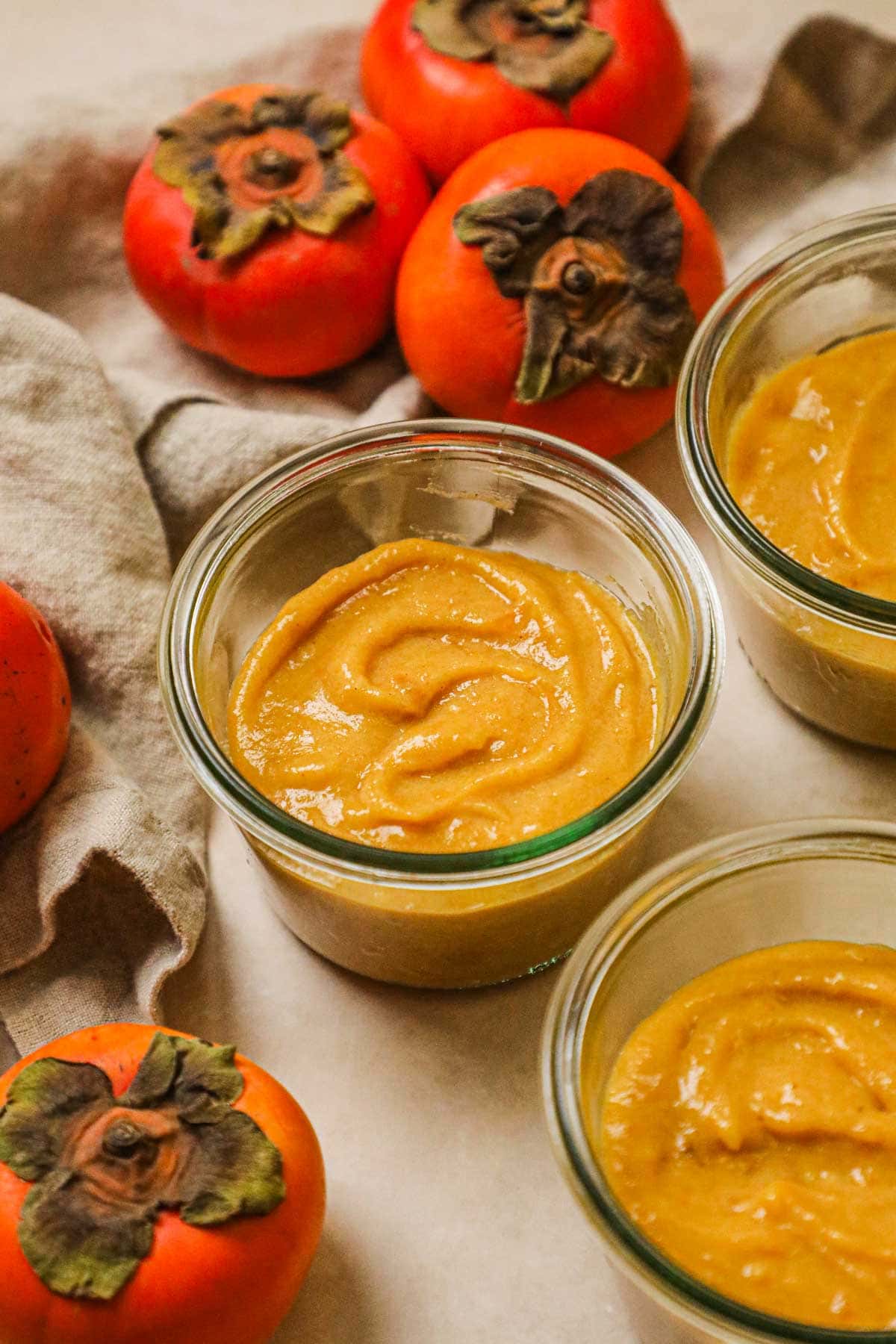 Homemade cinnamon persimmon curd in weck jars, made for spreading on toast, biscuits, waffles, and more, or drizzled on ice cream, yogurt, and more.