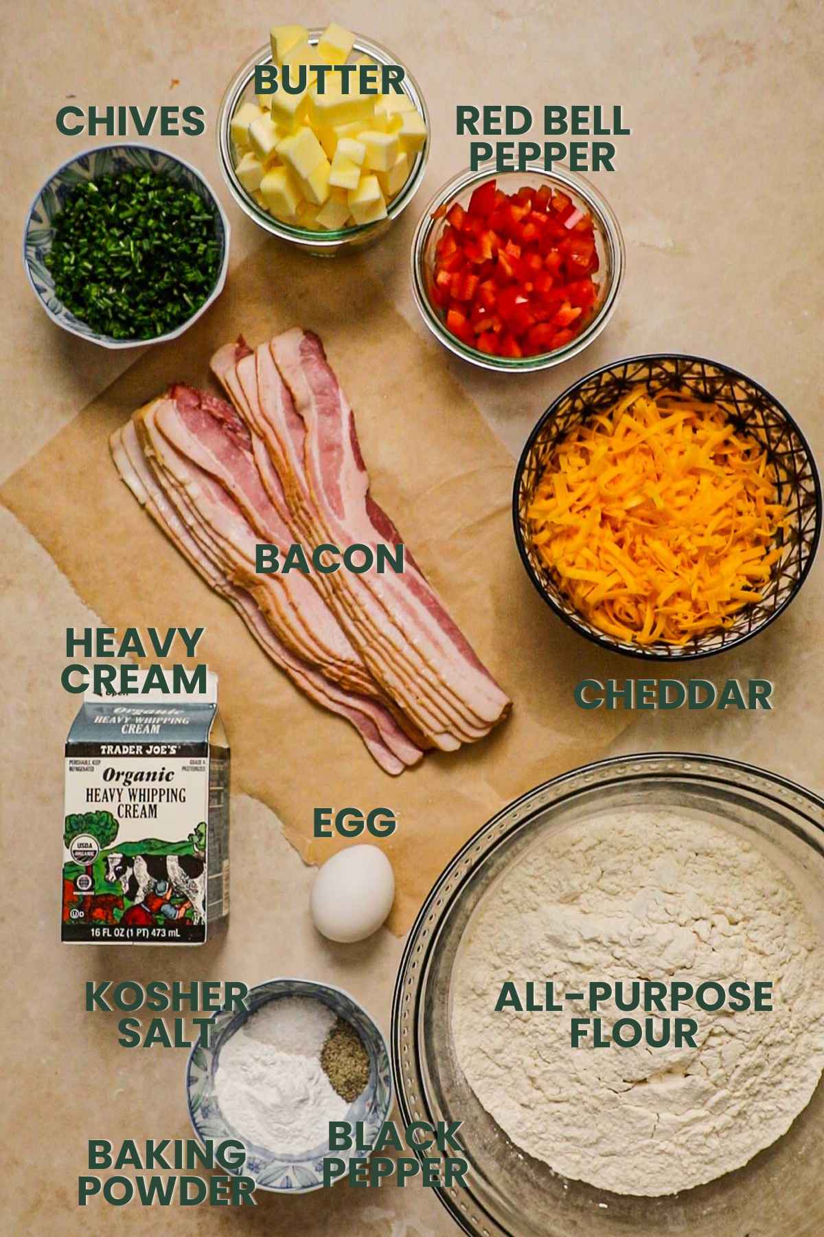 Ingredients for bacon cheddar chive biscuits, bacon, heavy cream, flour, cheddar, bell pepper, butter, chives, kosher salt, baking powder, black pepper.