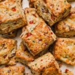 Pile of tender flaky bacon cheddar chive biscuits with buttery layers.
