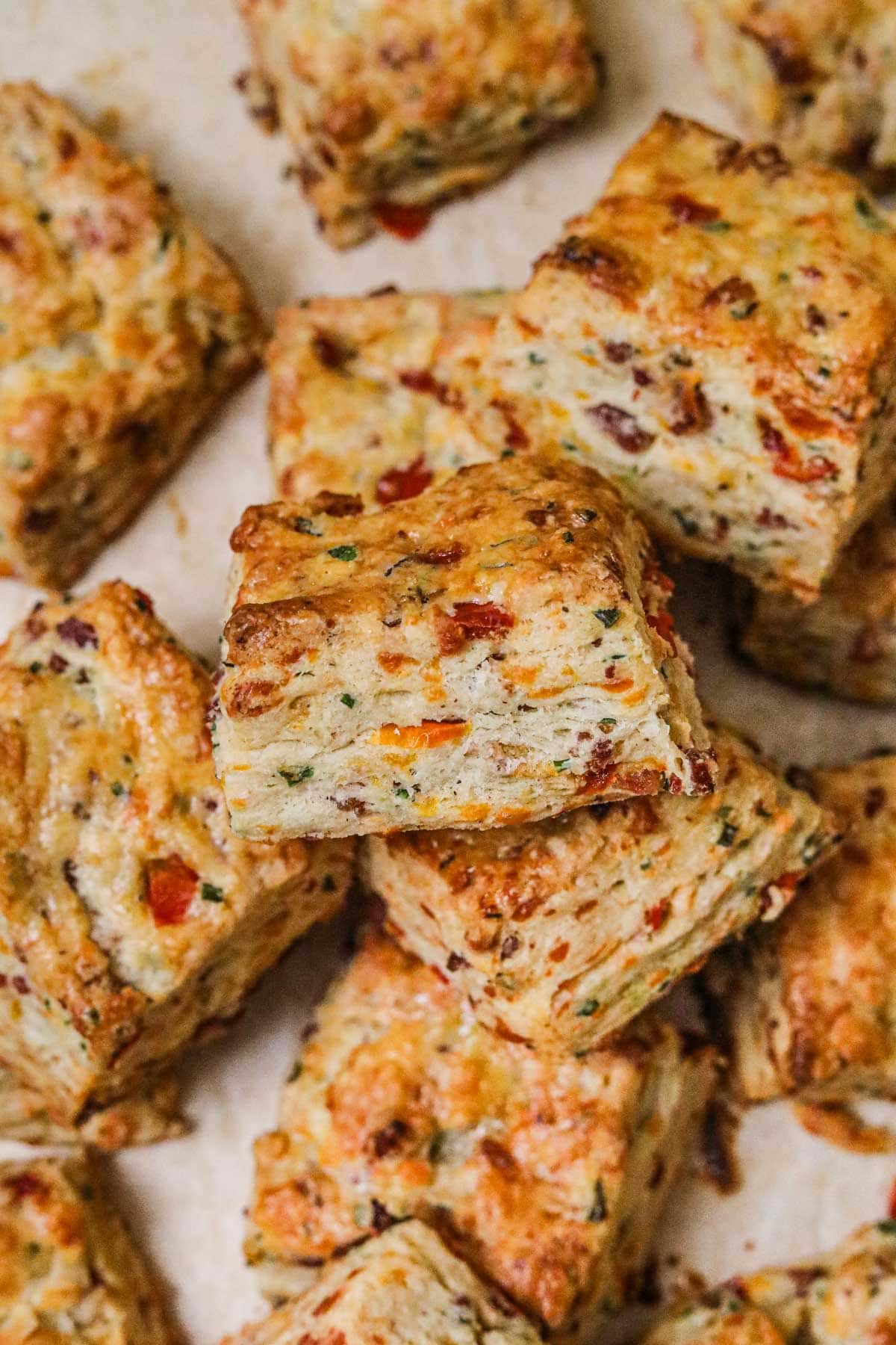 Closeup shot of flaky bacon cheddar chive biscuits with many buttery layers.